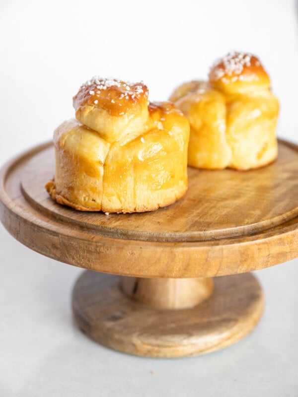 brioche buns on a wooden cake stand