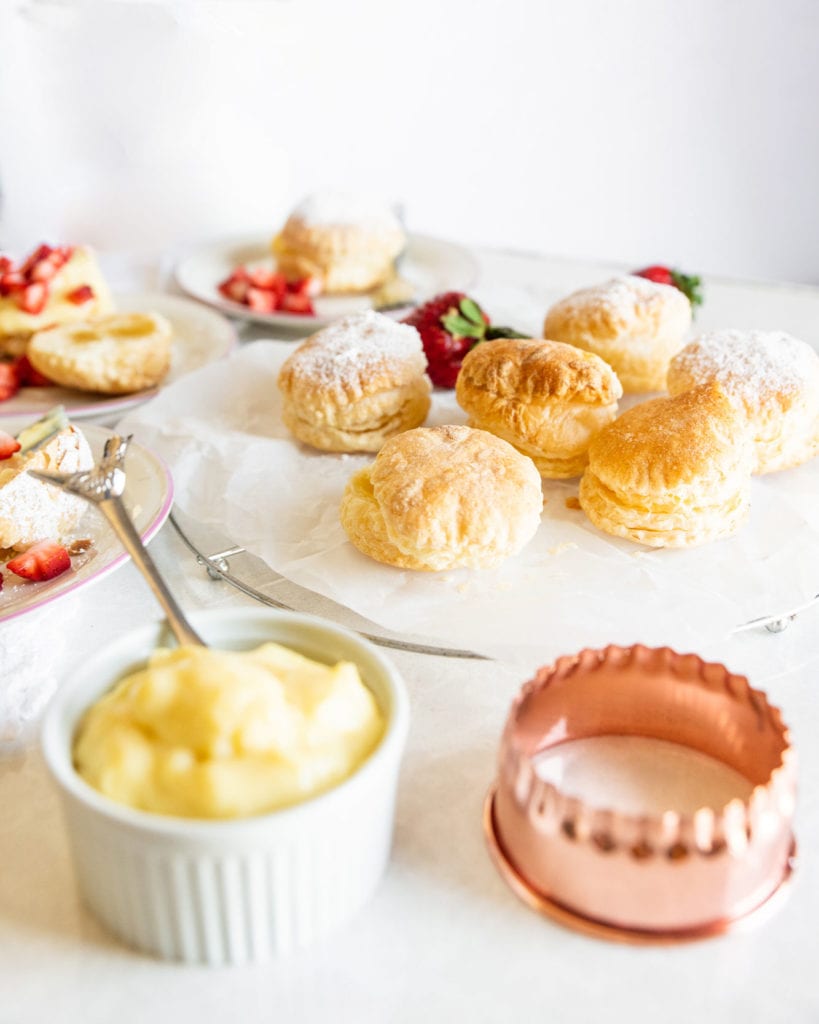 puff pastries filled with cream on a plate with strawberries