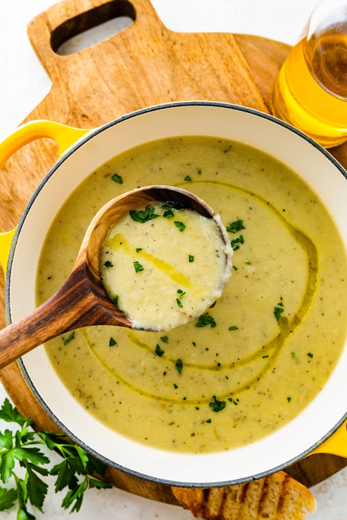 wooden ladle with artichoke soup over pot.