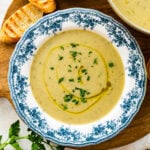old fashioned white and blue bowl with artichoke soup in it.