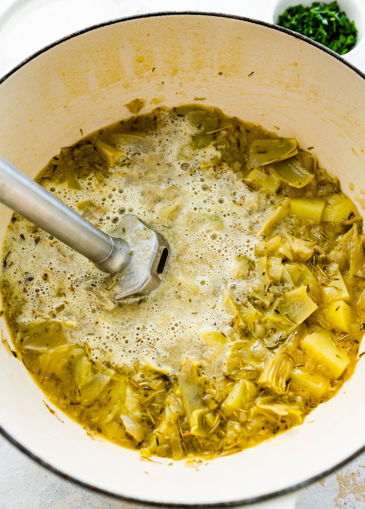 immersion blender in the pot blending the cooked soup.