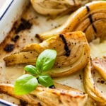 Oven roasted fennel on a pan garnished with fresh basil.