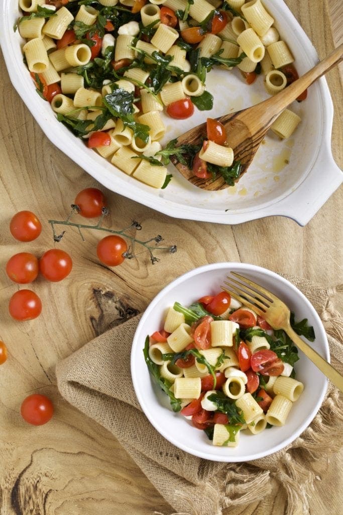 pasta salad with arugula, tomatoes, mozarella in a bowl