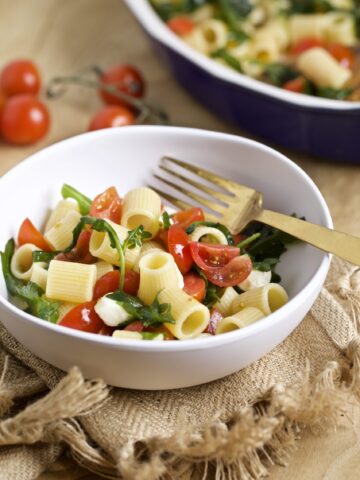 pasta salad with arugula, tomatoes, mozarella in a bowl
