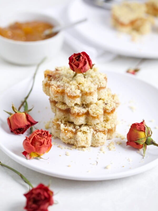 Italian Crumb cake with jam on a plate with dried roses