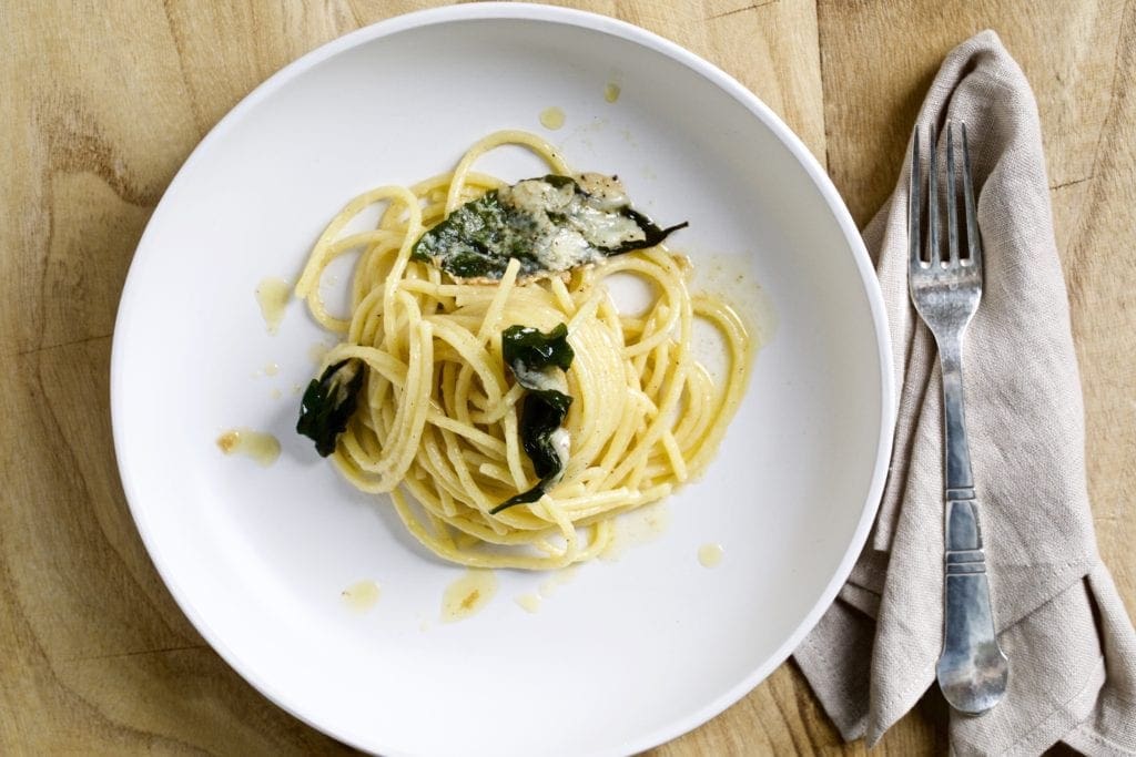 Plate of brown butter pasta with basil and cheese.