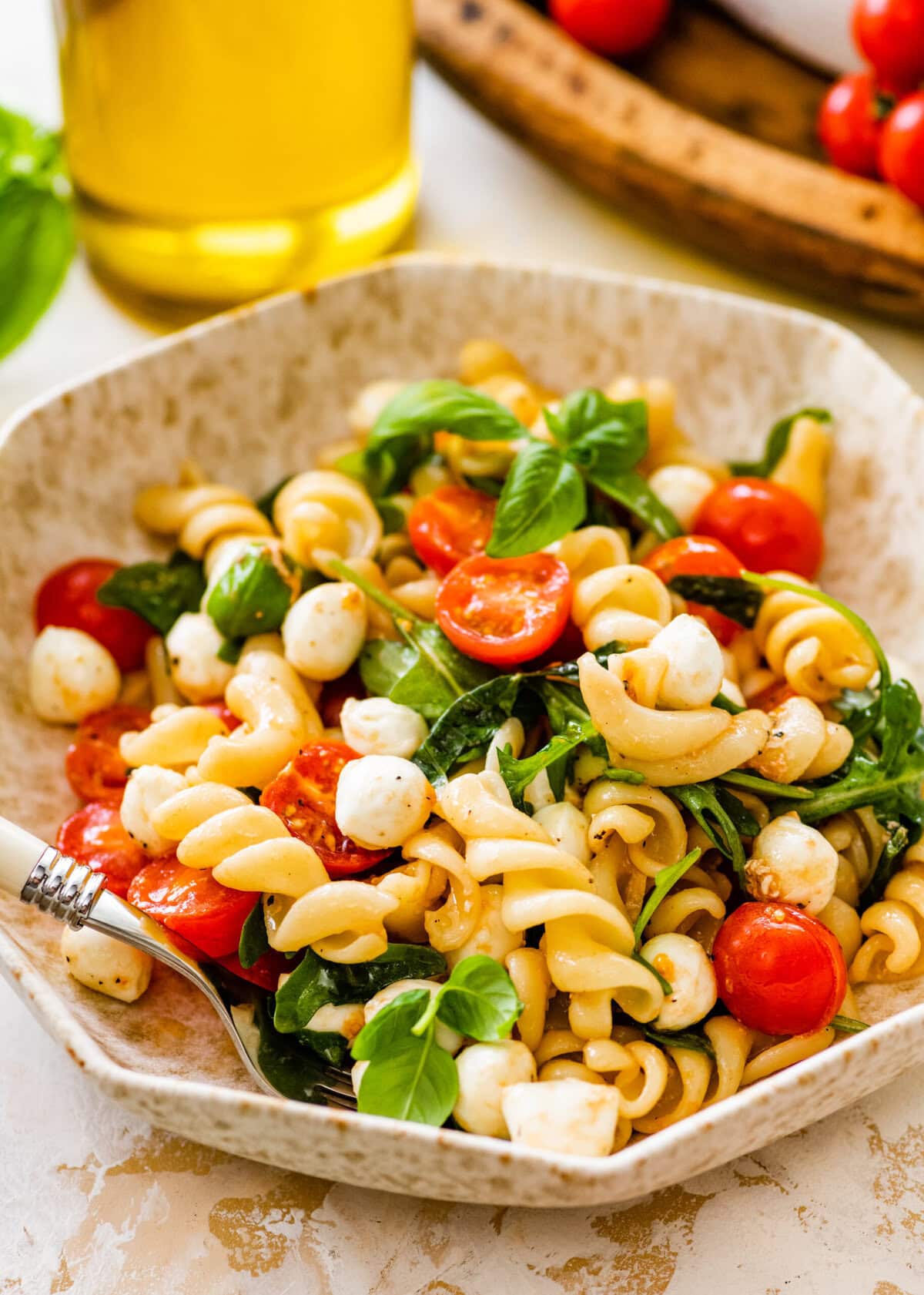 Caprese pasta salad with tomatoes, mozzarella, basil and parmesan cheese