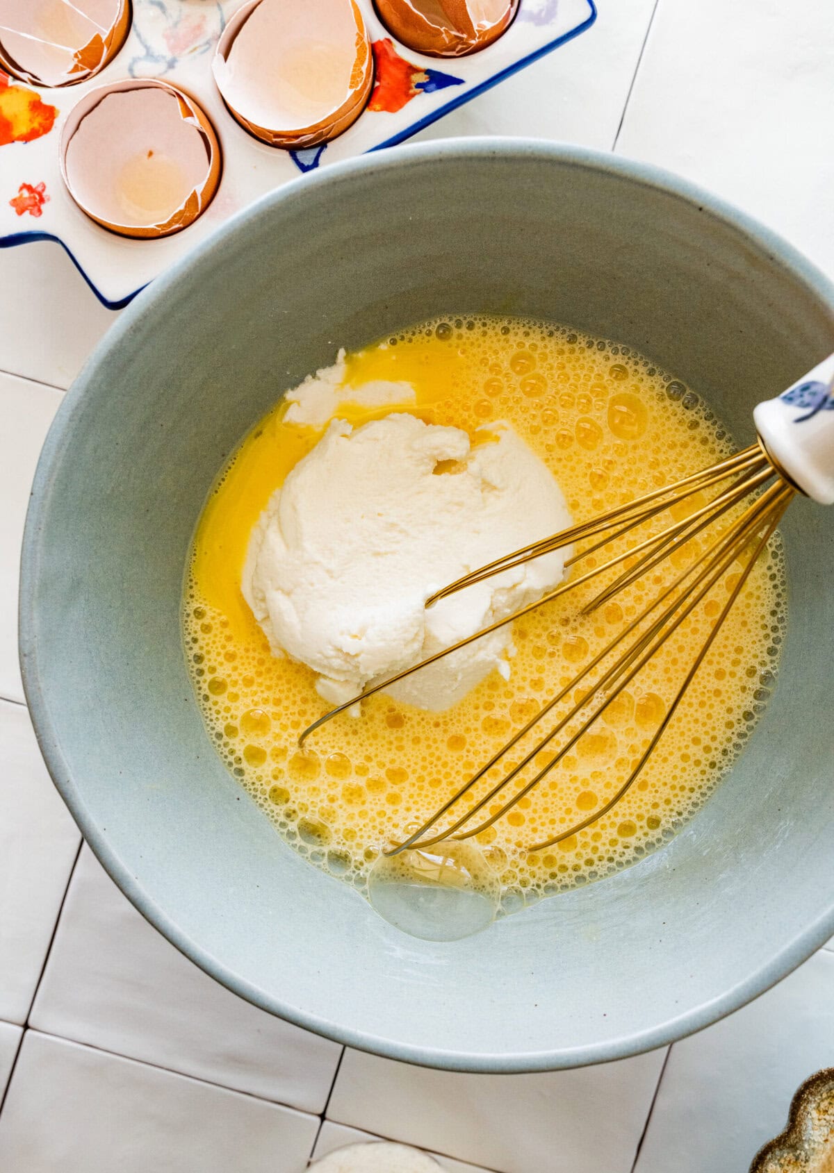 Eggs with ricotta added to the bowl.