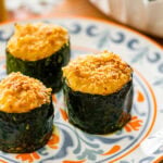 three Italian stuffed zucchini on a blue and orange small plate.