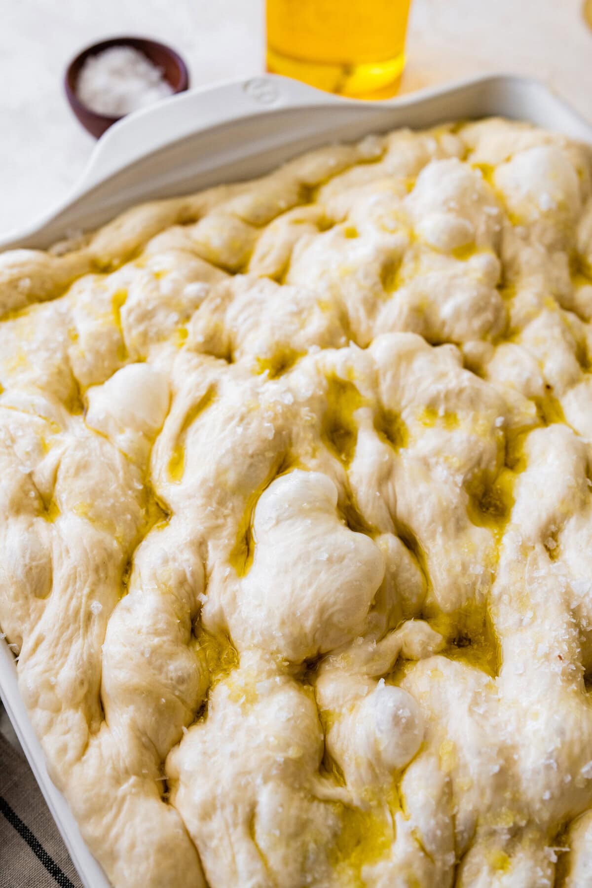 how to make no-knead focaccia bread step-by-step: dough with dimples. Ready to bake.