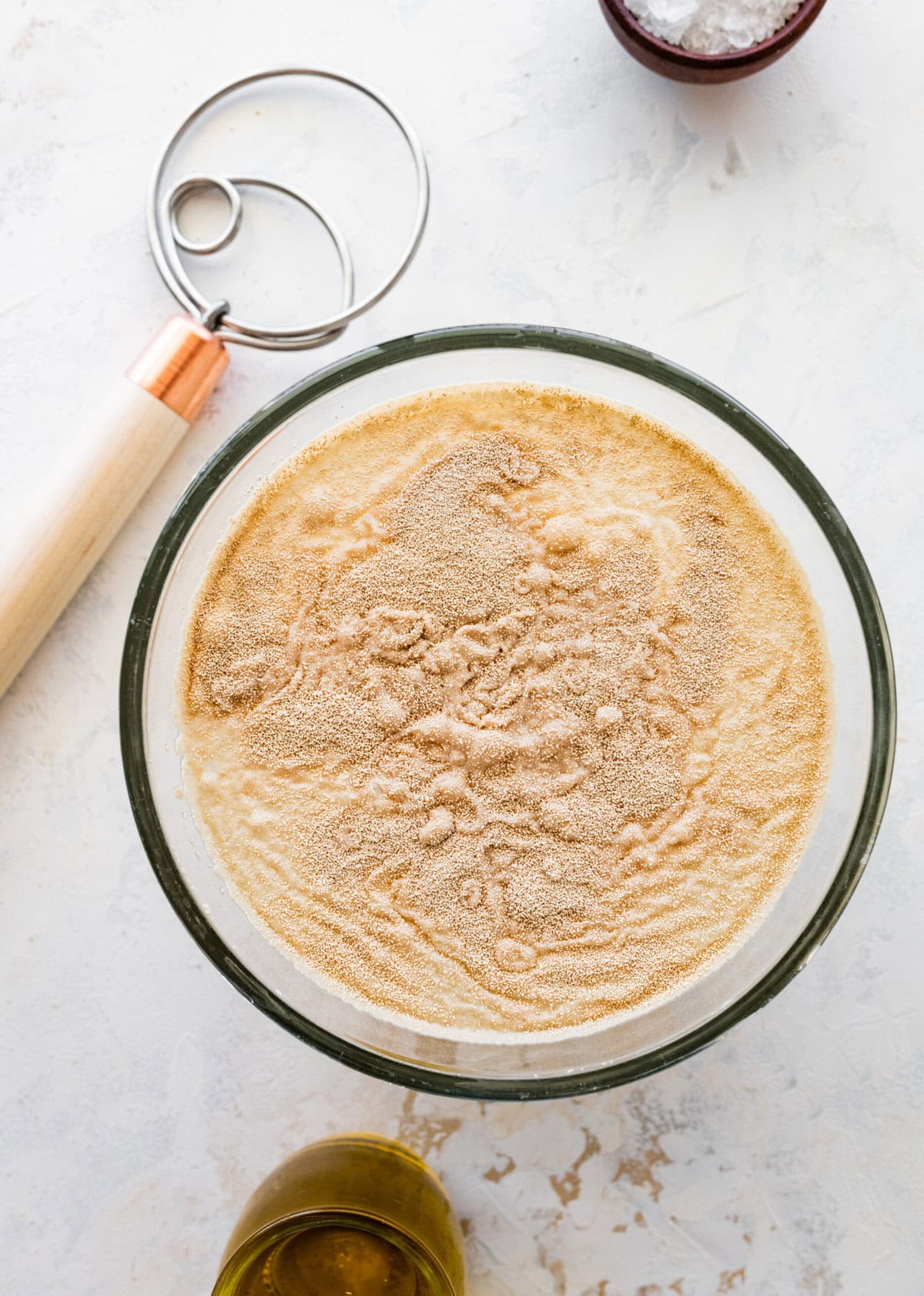 how to make no-knead focaccia bread step-by-step: add yeast and sugar to the water and let in bubble.