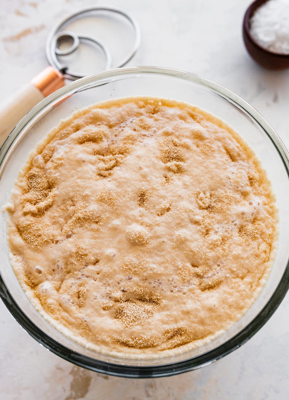 how to make no-knead focaccia bread step-by-step: add yeast and sugar to the water and let in bubble. When the yeast is activated you will see bubbles at the top.