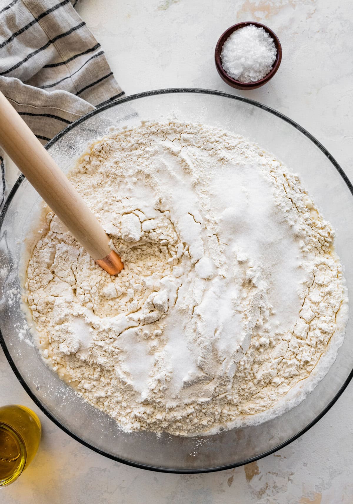 how to make no-knead focaccia bread step-by-step: add flour to the yeast and water mixture.