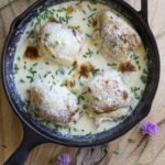 Chicken in a creamy chive mascarpone sauce in a skillet.