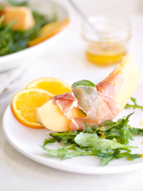 Cantaloupe Melon on plate wrapped in prosciutto with citrus vinaigrette