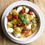 pasta salad in a bowl with cheese and vegetables