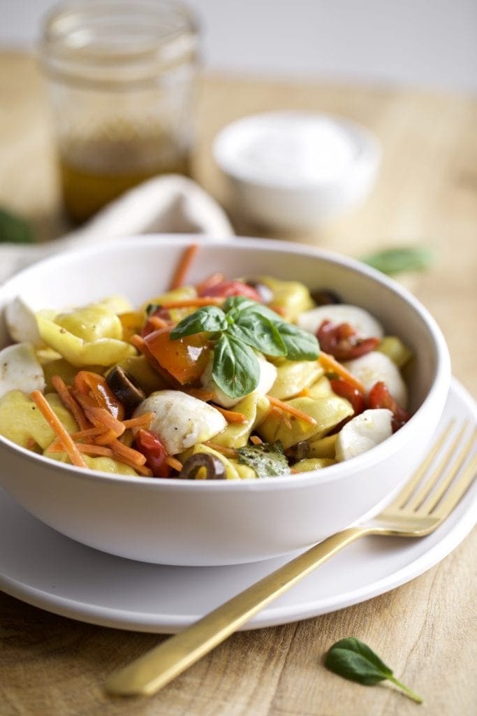 pasta salad in a bowl with cheese and vegetables