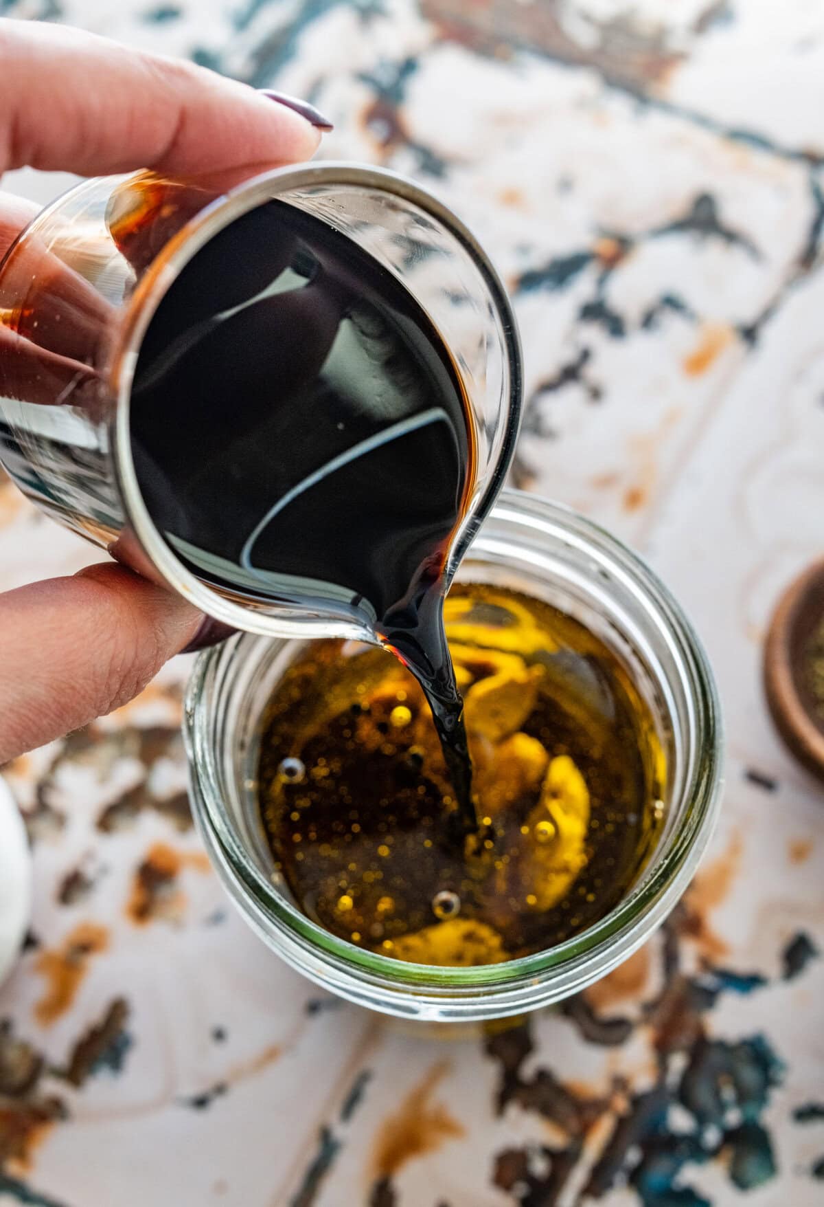 Adding the balsamic to a jar with the other ingredients. 