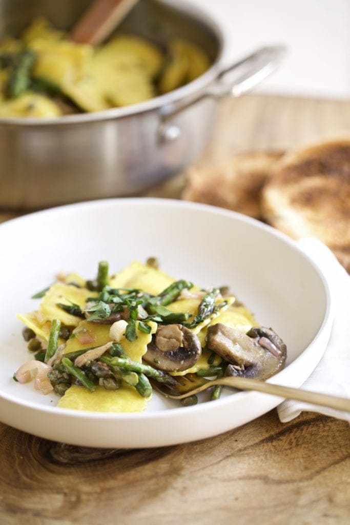Ravioli Piccata mushrooms and asparagus on a plate with grilled bread