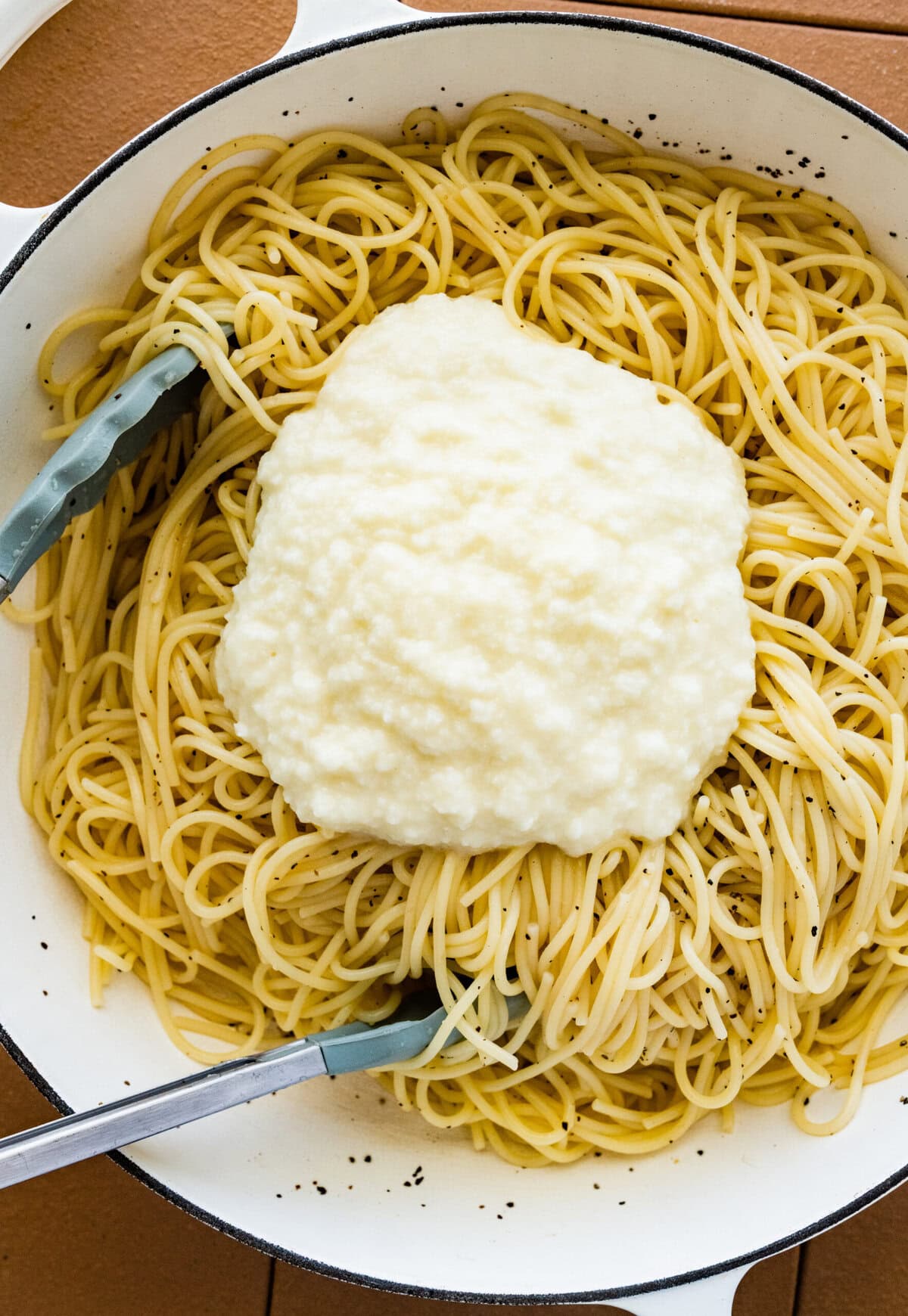 add the parmigiano cheese mixture to the pasta and pepper in the pan.