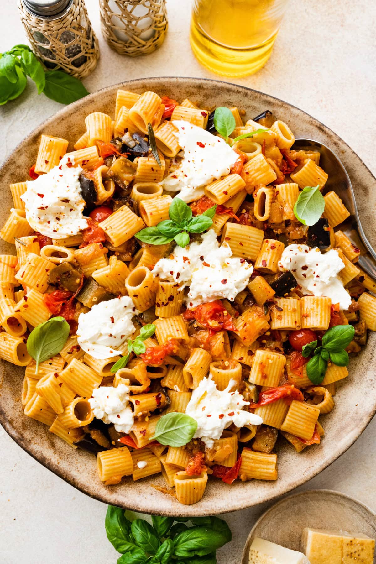plated eggplant pasta with basil and burrata on top.