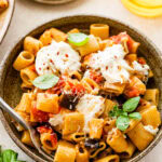 bowl of the eggplant pasta with burrata on top and fork in it.