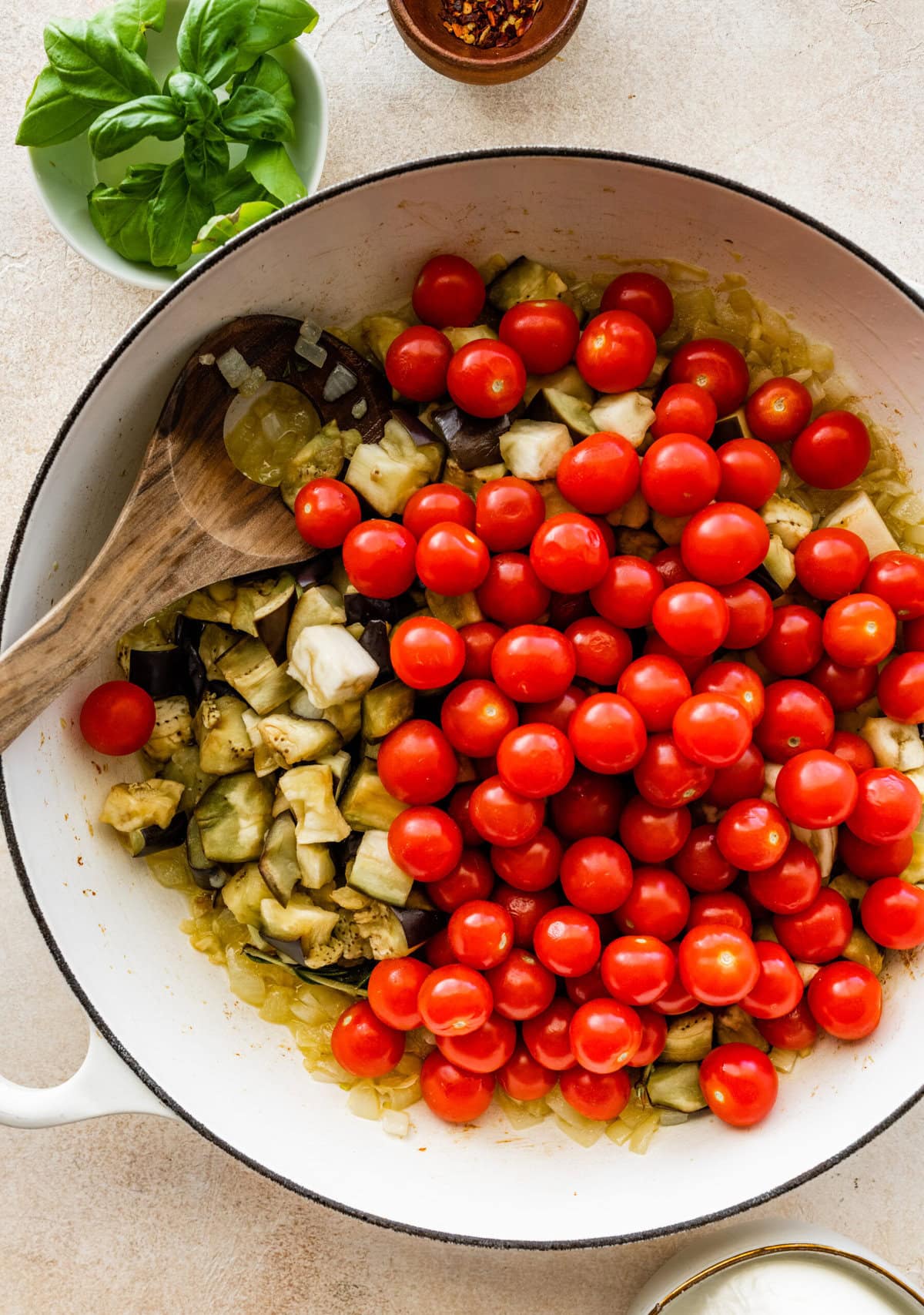 add fresh tomatoes and eggplant to the pan with olive oil.