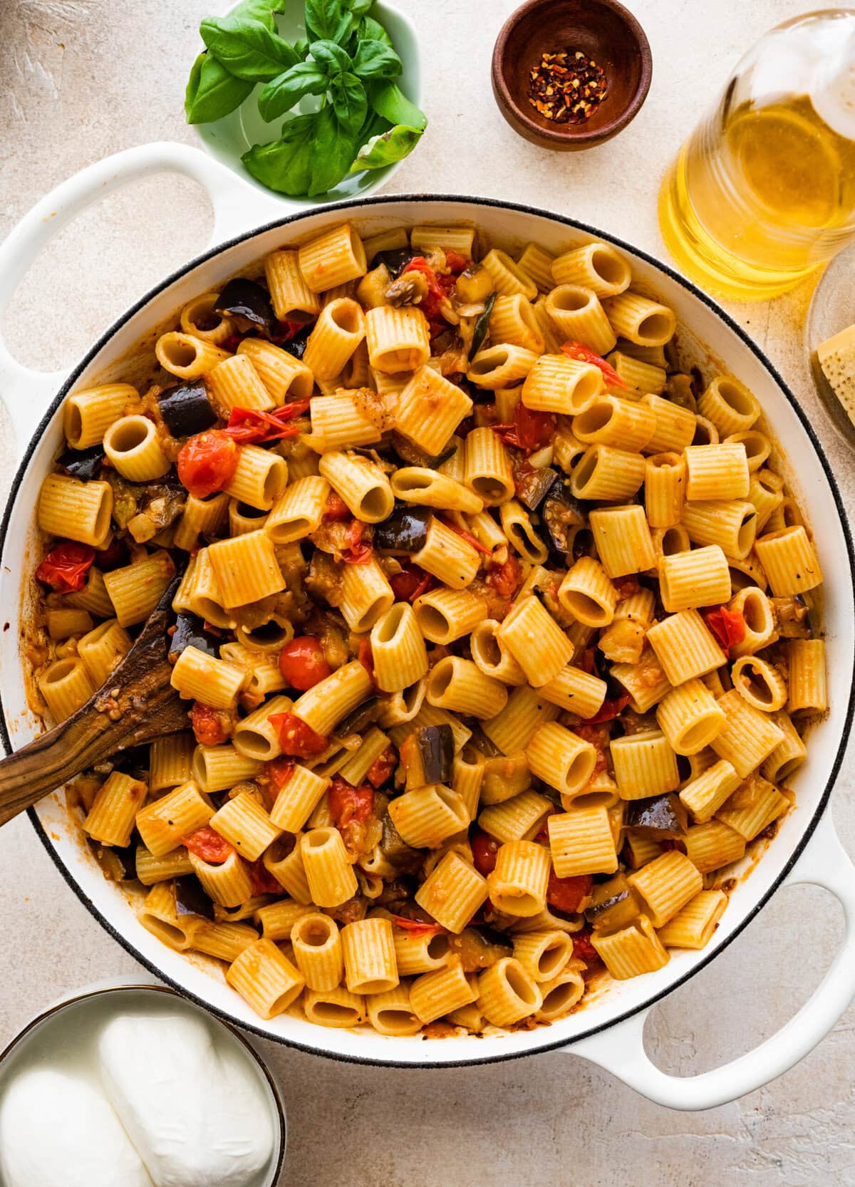 eggplant pasta in the baking dish with a wooden spoon.