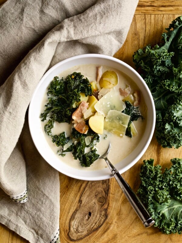 Spoon in a bowl of zuppa Toscana with bacon, potato, and kale.