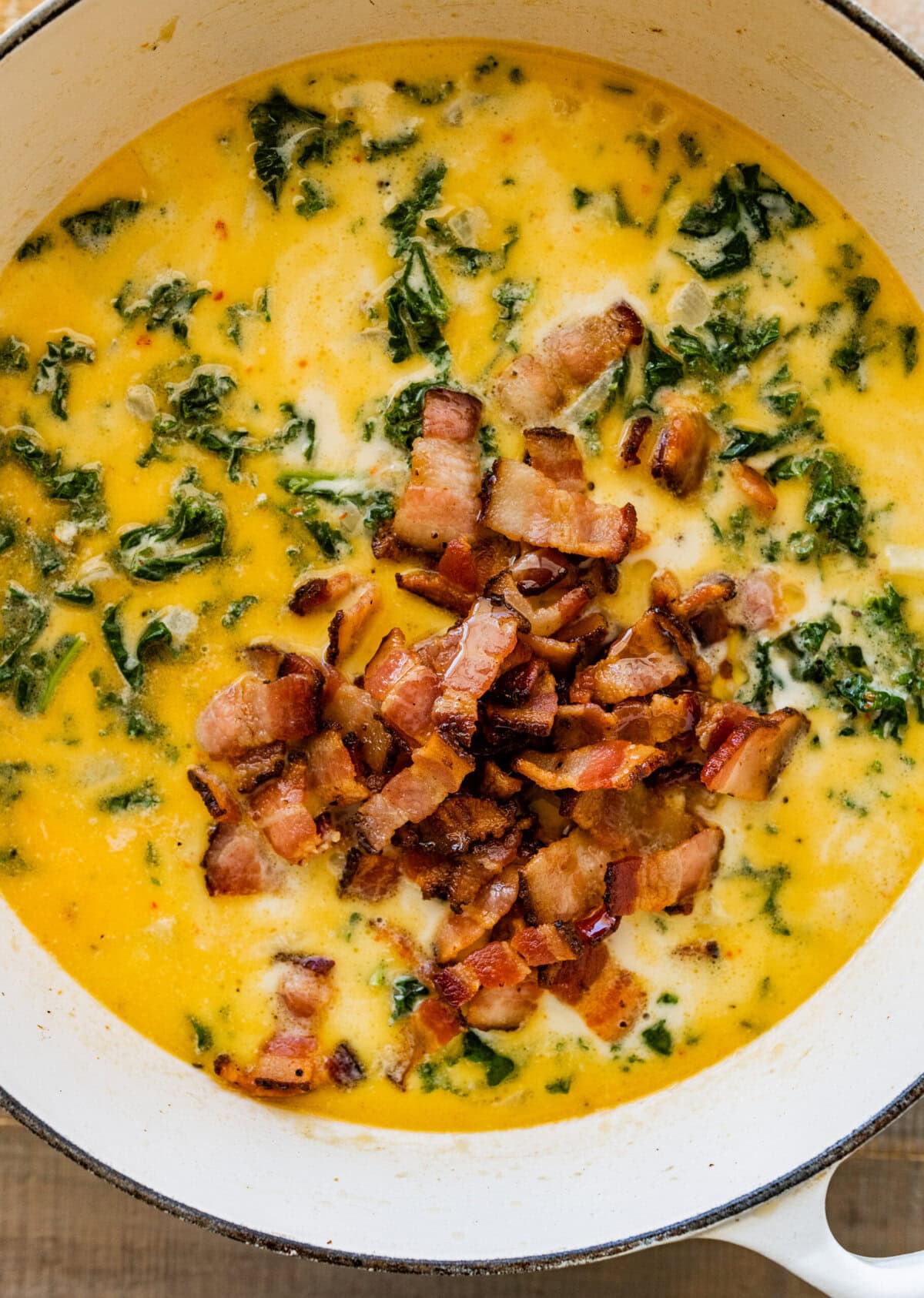 Adding the bacon to teh pot of zuppa toscana. 