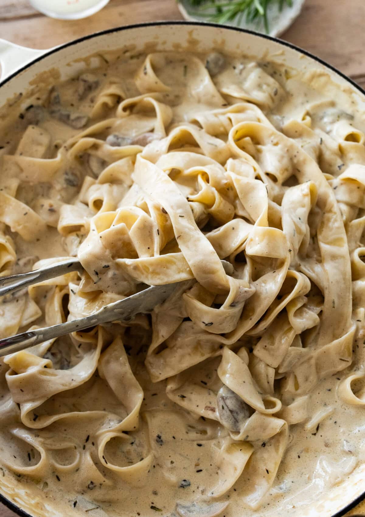 mixing the pasta with the sauce.