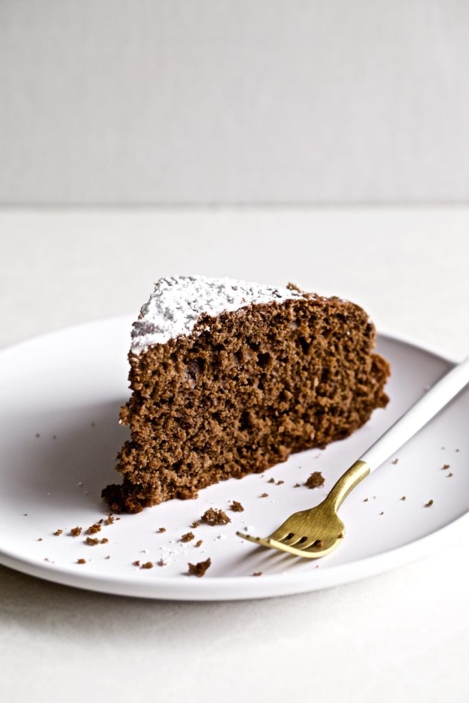 Slice of Italian flourless chocolate torte on a plate with a fork.