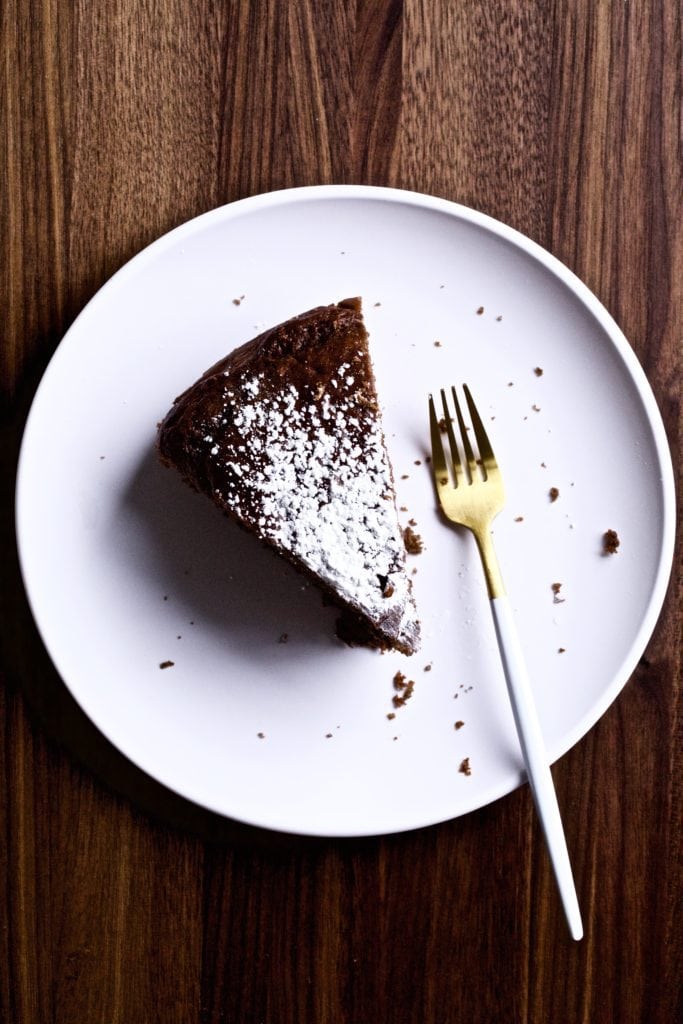 Slice of Italian flourless chocolate torte on a plate with a fork.