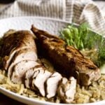 Sliced pork tenderloin with shallots and fennel on a tray.