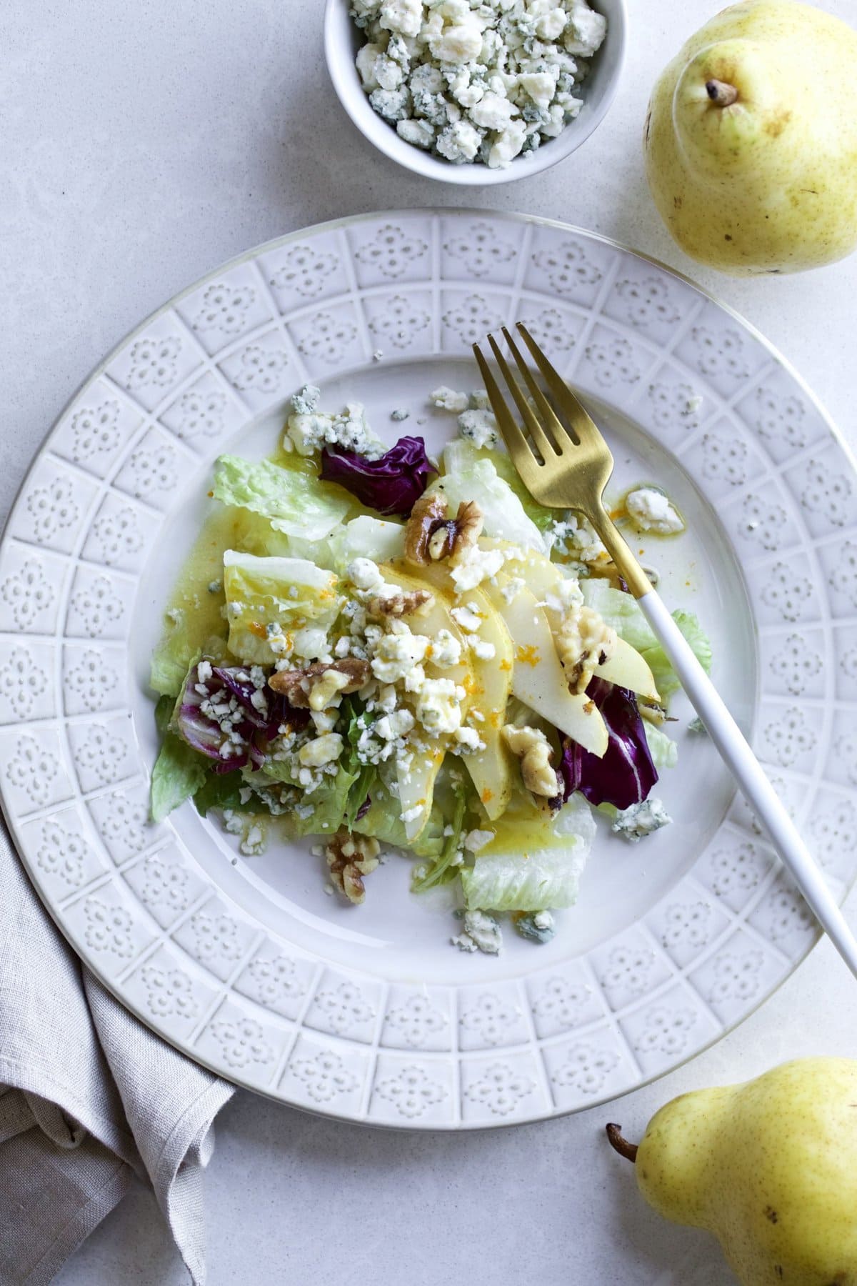 Italian Green Salad Pears, Walnuts, Gorgonzola Orange Honey Vinaigrette on a plate