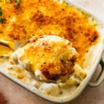 scooping a portion of the creamy cheesy cauliflower casserole.