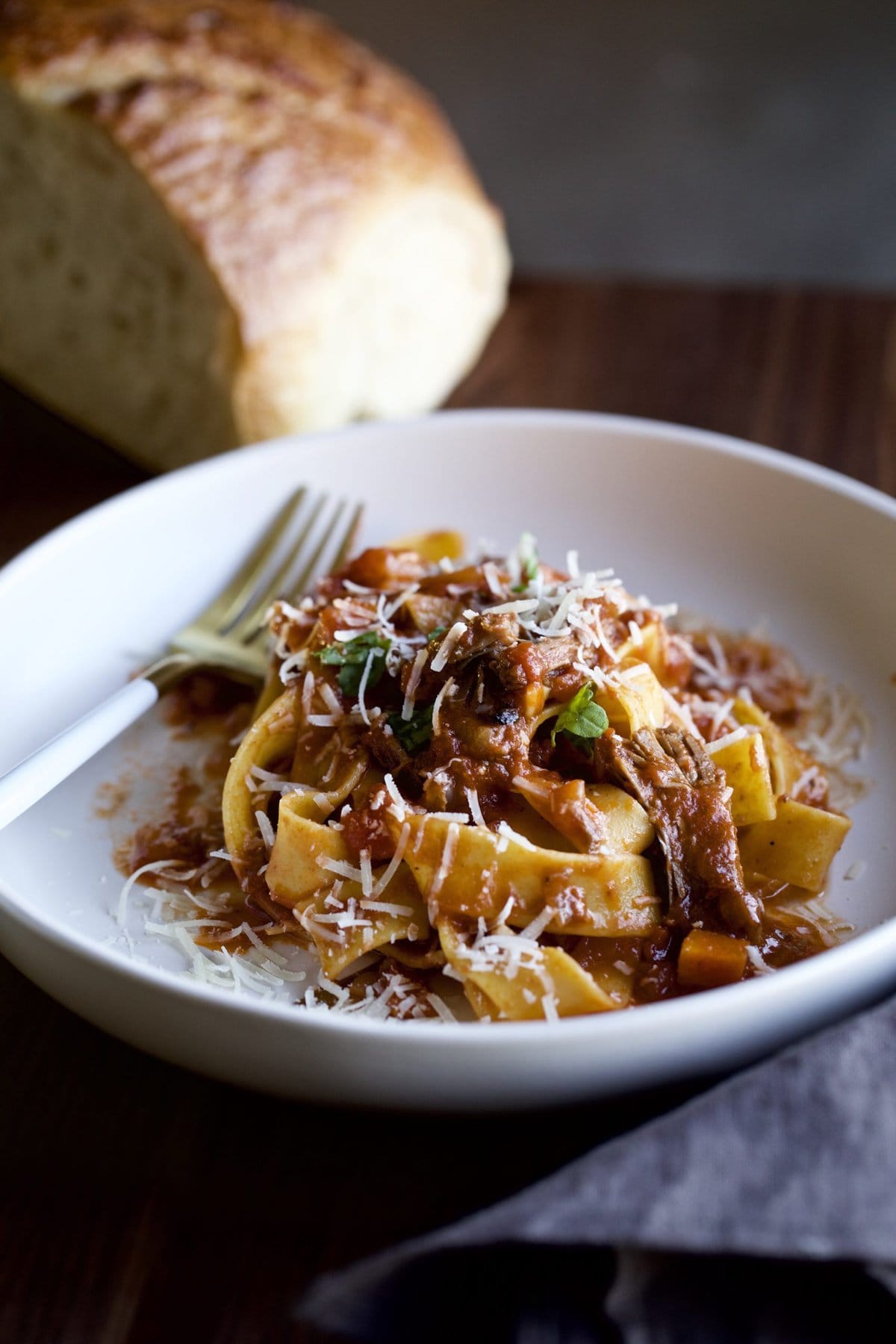 Fork on a plate of beef short rib sauce with pappardelle pasta.