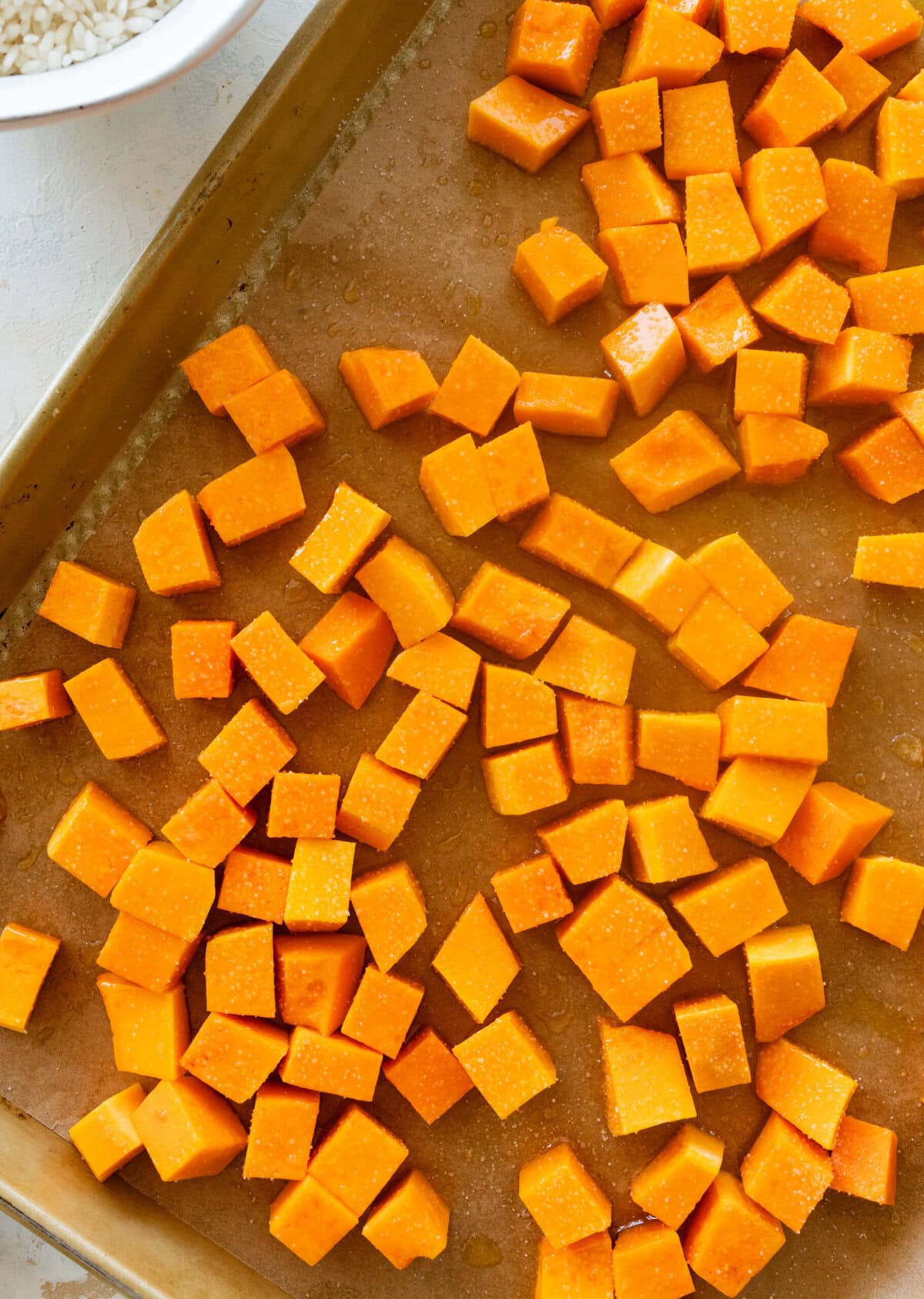 Butternut squash cubes on a baking sheet.