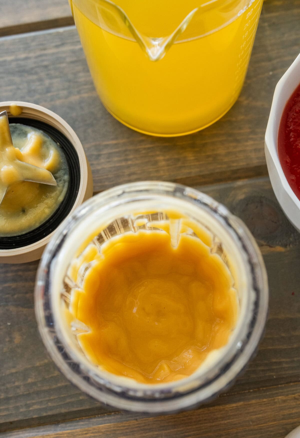 Chickpeas in a blender blended, with ingredients for the recipe nearby.