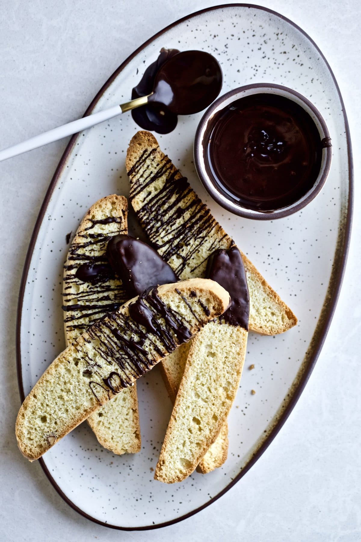 Italian biscotti with chocolate drizzle on a plate.