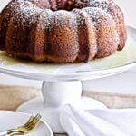 Poppy seed cake with orange almond vanilla glaze on a raised platter.