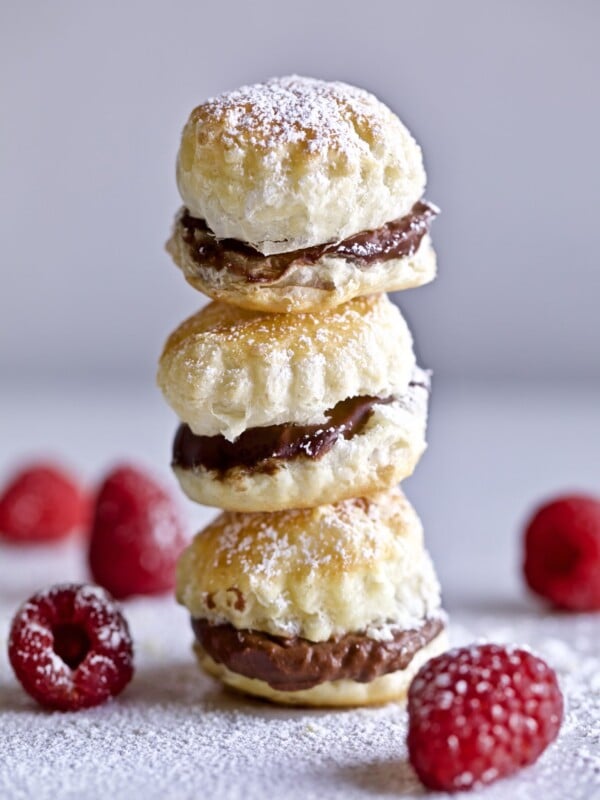 chocolate cream puffs with raspberries on the side