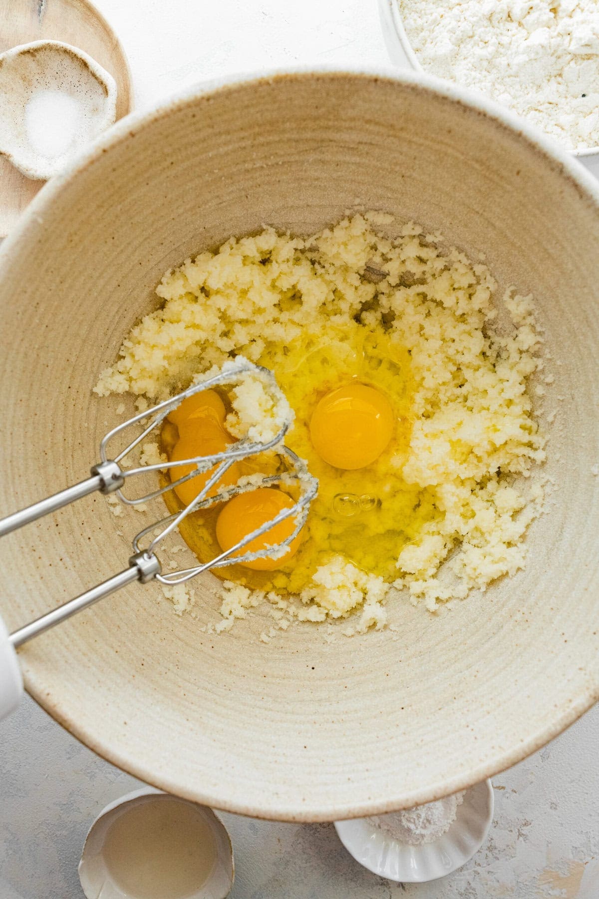 Adding eggs to the beaten sugar and butter.