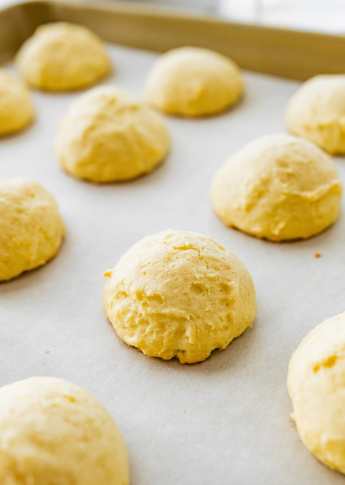 Baked anginetti cookies on a cookie sheet.