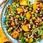 Italian orange and fennel salad with orange dressing on the side. Wooden salad servers on the side.