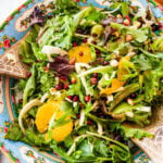 Italian orange and fennel salad with orange dressing on the side. Wooden salad servers on the side.