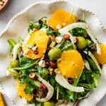 Italian orange and fennel salad on a plate. Orange slices cut in rounds and fennel visible on top.