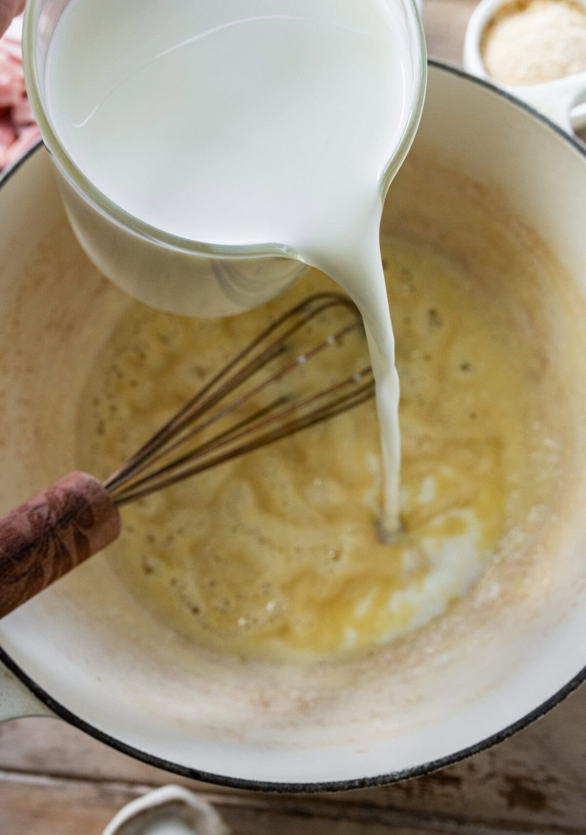 Pouring milk into the roux,