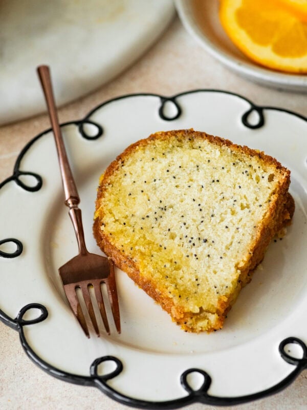 a slice of poppy seed cake on a dish with a fork.