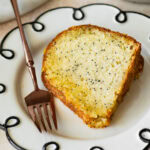 a slice of poppy seed cake on a dish with a fork.